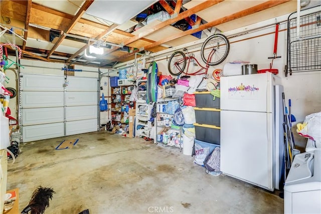 garage featuring washer / dryer and white refrigerator