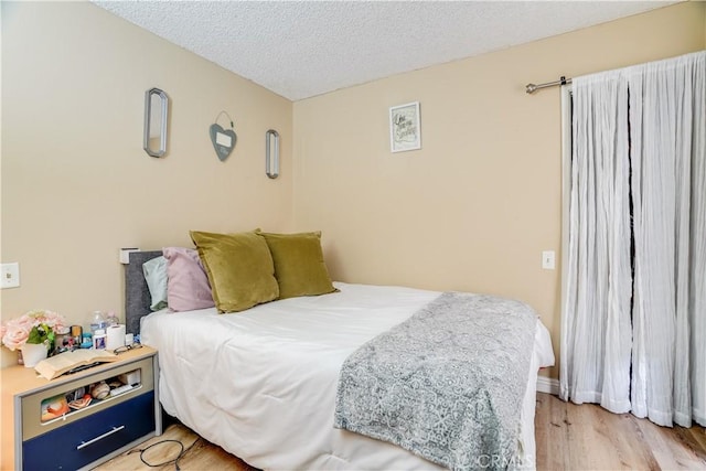 bedroom with a textured ceiling and light wood-type flooring