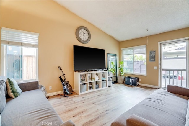 living room featuring lofted ceiling and light hardwood / wood-style flooring