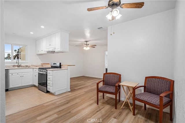 kitchen with white cabinetry, sink, ceiling fan, stainless steel appliances, and light wood-type flooring