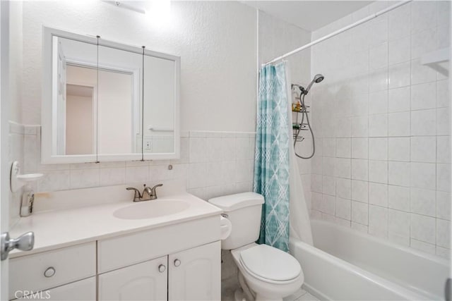 full bathroom featuring vanity, toilet, shower / tub combo, and tile walls