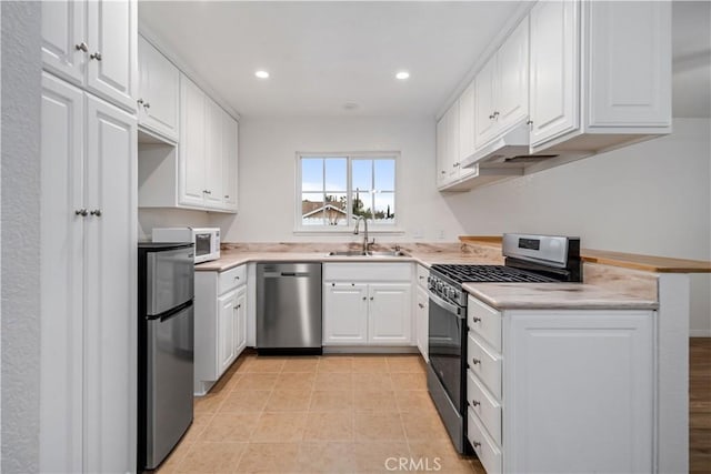 kitchen with sink, light tile patterned floors, stainless steel appliances, and white cabinets