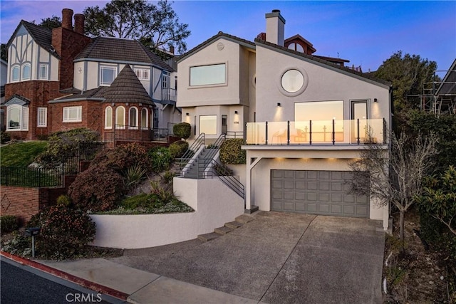 view of front facade with driveway, stucco siding, and an attached garage