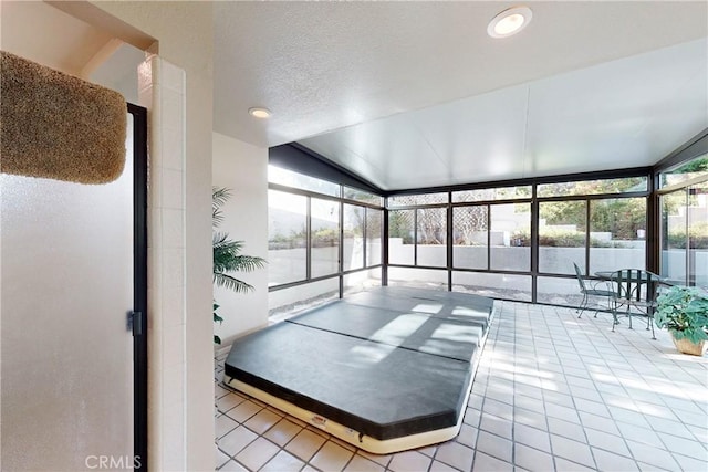 interior space with tile patterned floors, plenty of natural light, and lofted ceiling