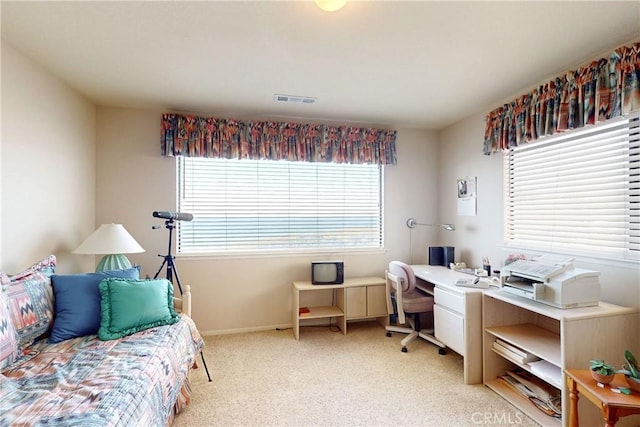 office area featuring baseboards, visible vents, and light carpet