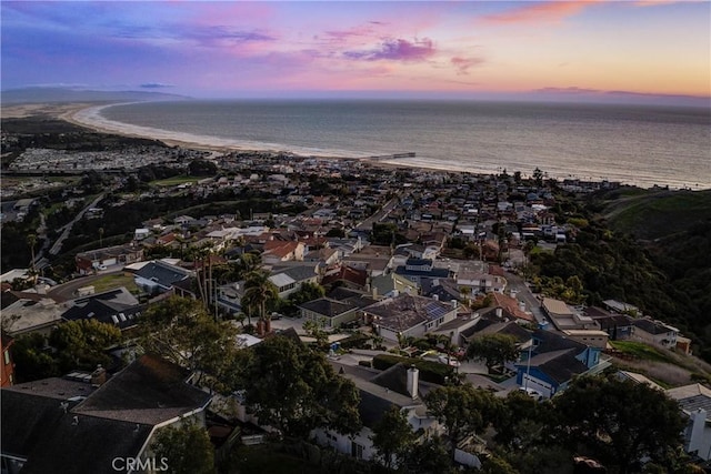 aerial view at dusk featuring a water view