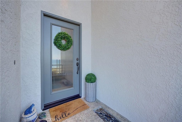view of exterior entry with stucco siding