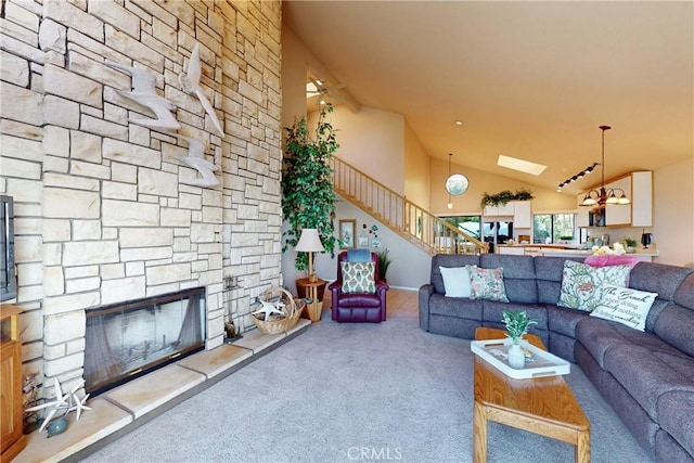 living area with carpet floors, a stone fireplace, high vaulted ceiling, and stairway