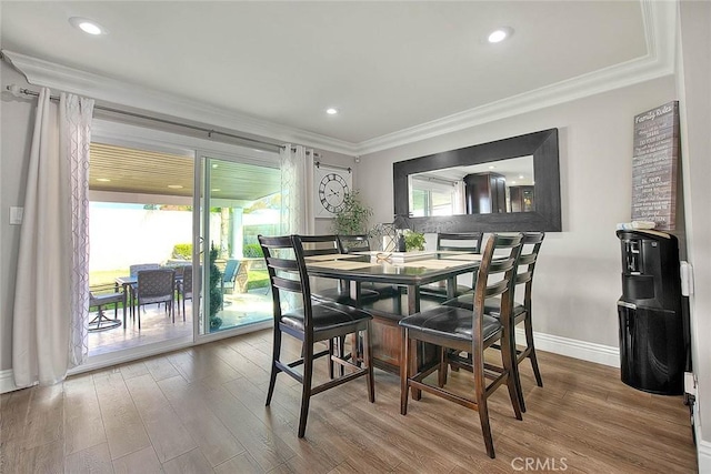 dining area with hardwood / wood-style flooring and ornamental molding