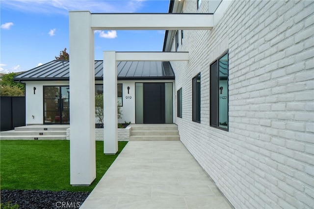 919 Sandcastle Dr, Corona Del Mar, CA 92625 - property entrance with a standing seam roof, a yard, and metal roof