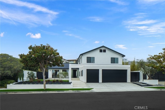 view of front of house with a garage, driveway, fence, and stucco siding