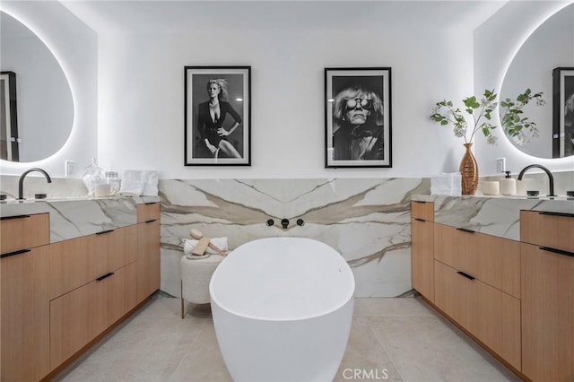 919 Sandcastle Dr, Corona Del Mar, CA 92625 - full bathroom featuring two vanities, tile walls, a freestanding tub, and tile patterned floors