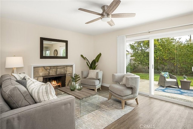 living room with hardwood / wood-style flooring, a fireplace, and ceiling fan