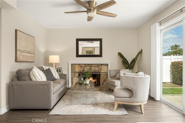 living room featuring ceiling fan, a fireplace, and hardwood / wood-style floors