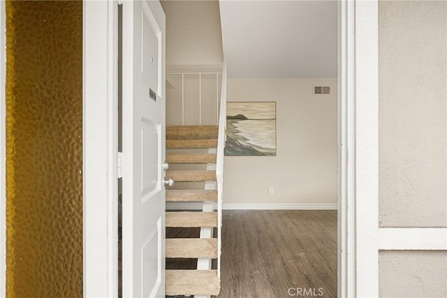 staircase with hardwood / wood-style floors