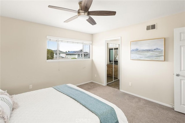 bedroom with ensuite bathroom, ceiling fan, and carpet