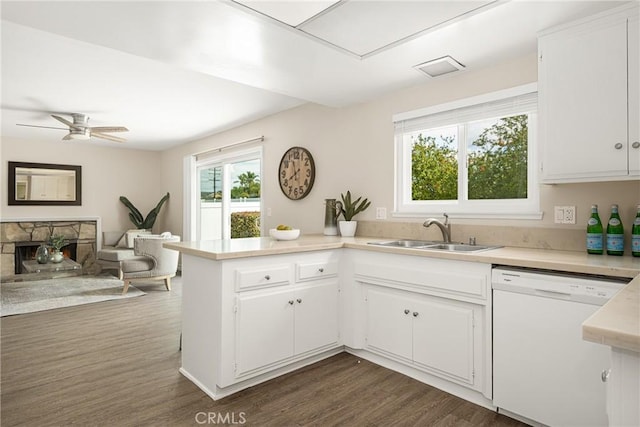 kitchen featuring dark hardwood / wood-style floors, a fireplace, white cabinetry, dishwasher, and sink