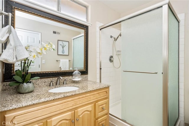 bathroom featuring vanity and an enclosed shower