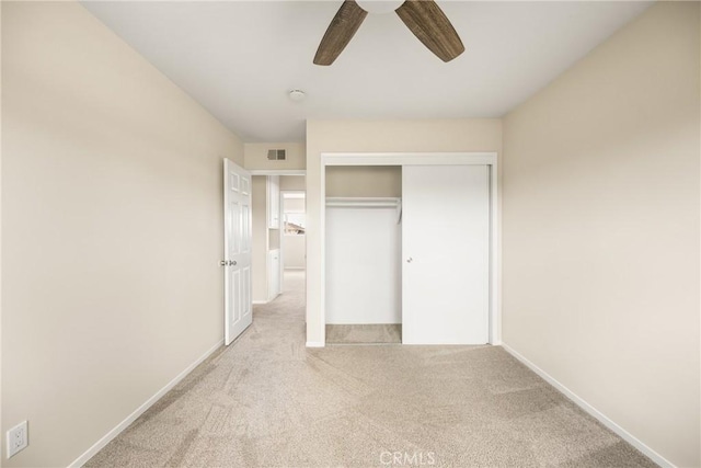 unfurnished bedroom with light carpet, a closet, and ceiling fan