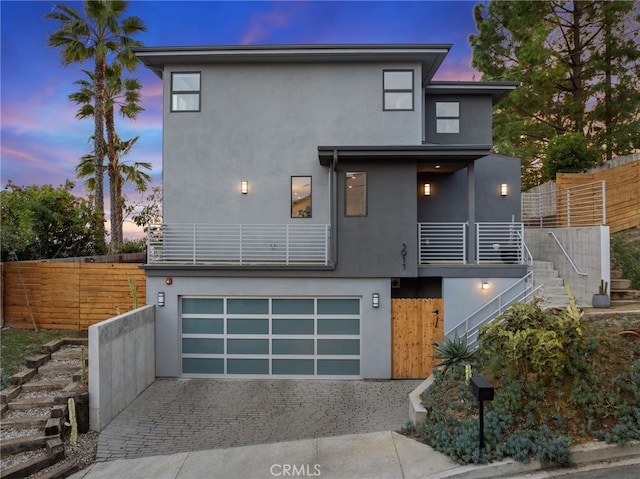 contemporary home featuring a garage and a balcony