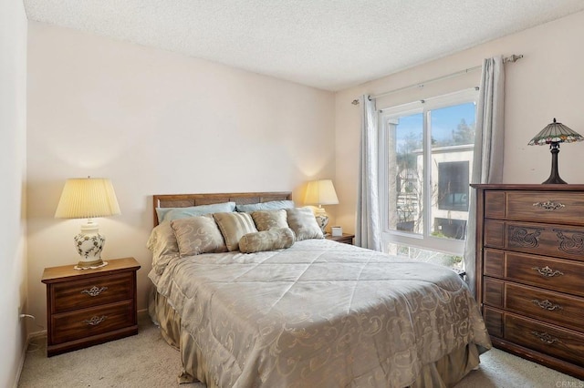 bedroom with light colored carpet and a textured ceiling