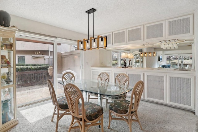 carpeted dining space with a textured ceiling