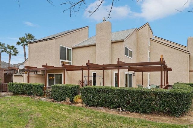 rear view of property with a pergola and a lawn