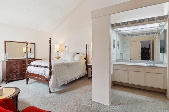 bedroom featuring lofted ceiling, sink, and light carpet