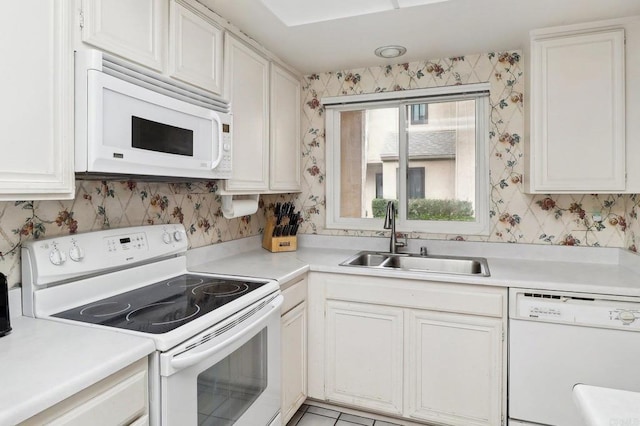 kitchen featuring white appliances, sink, and white cabinets