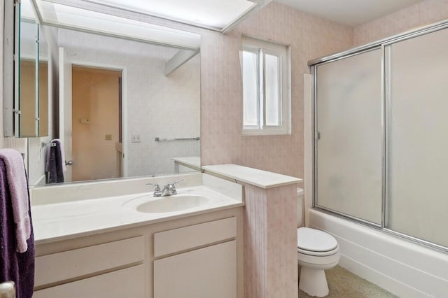 full bathroom with vanity, toilet, and combined bath / shower with glass door