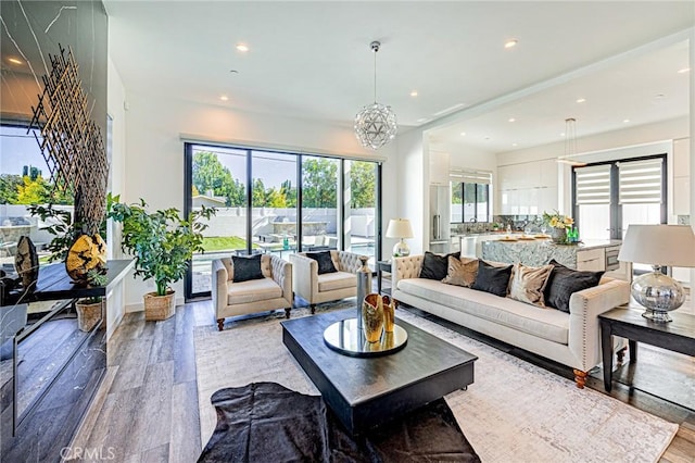 living room featuring a chandelier and light hardwood / wood-style flooring