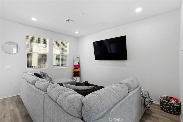 living room featuring baseboards, light wood-style flooring, visible vents, and recessed lighting