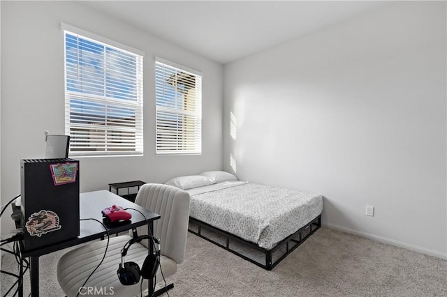 bedroom featuring baseboards and light colored carpet