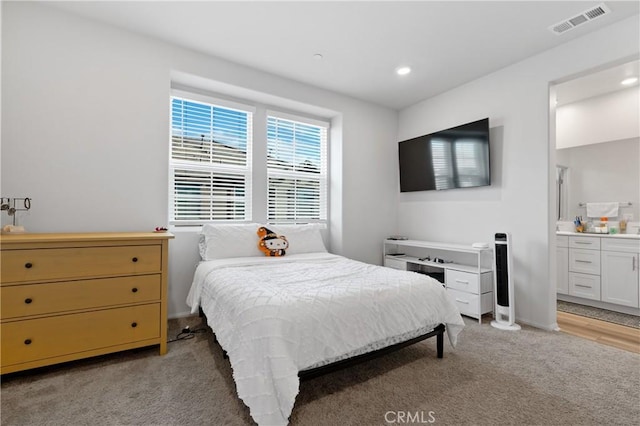 bedroom with light carpet, baseboards, visible vents, connected bathroom, and recessed lighting