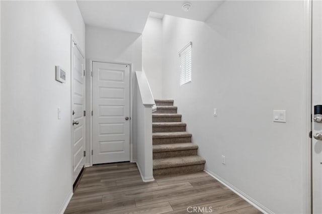 entrance foyer featuring baseboards, stairway, and wood finished floors