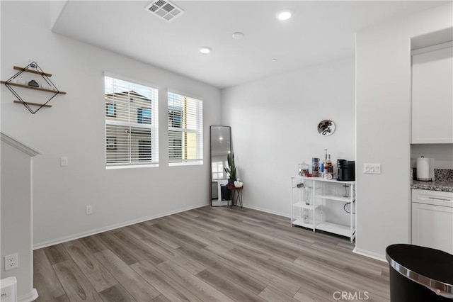 interior space featuring light wood-type flooring, baseboards, visible vents, and recessed lighting