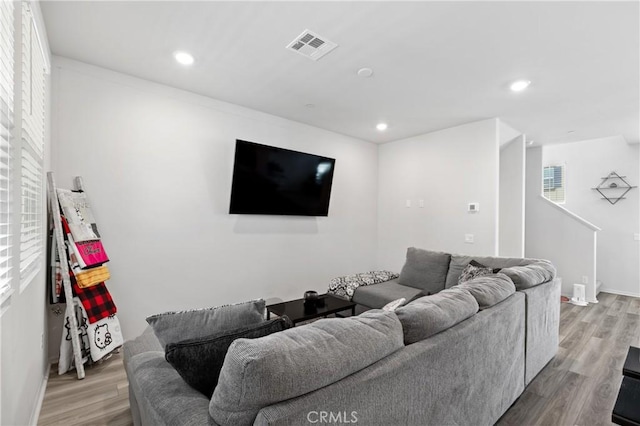 living area featuring light wood-style flooring, stairs, visible vents, and recessed lighting