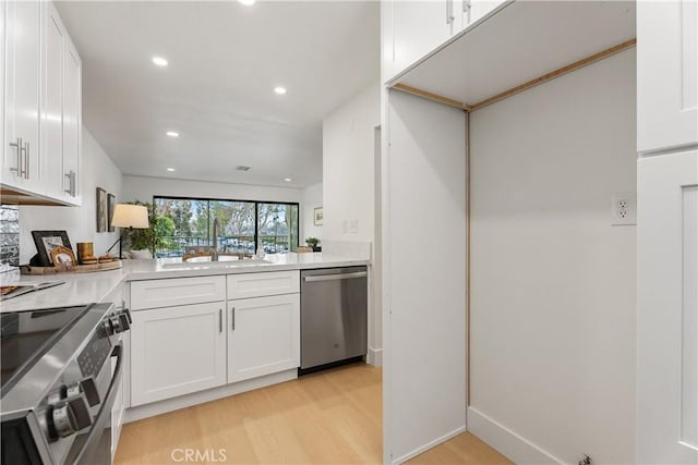 kitchen featuring appliances with stainless steel finishes, light countertops, white cabinetry, and light wood-style floors