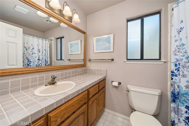 bathroom with vanity, visible vents, toilet, baseboards, and tasteful backsplash