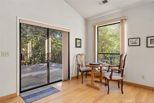 interior space featuring baseboards, lofted ceiling, wood finished floors, and visible vents