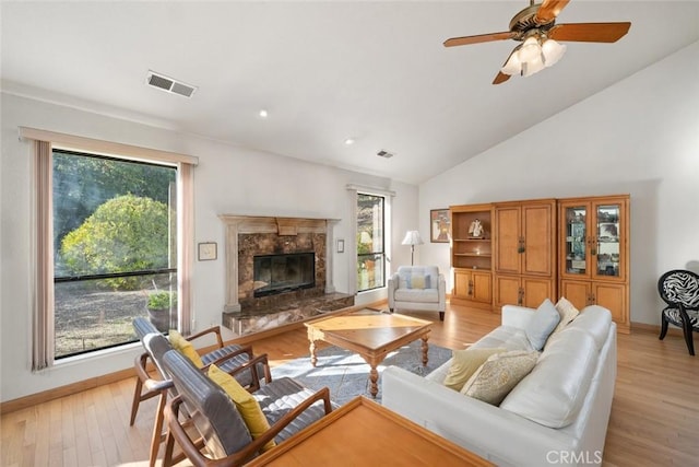 living area with visible vents, light wood-style flooring, and a wealth of natural light