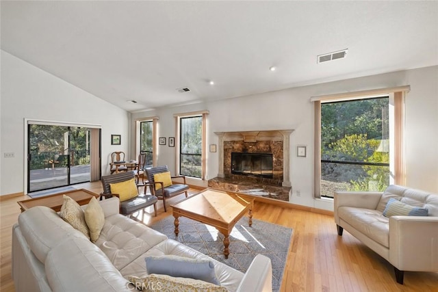 living area with visible vents, light wood-style flooring, and vaulted ceiling