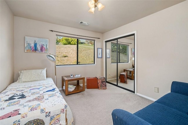 carpeted bedroom featuring baseboards, a closet, and visible vents