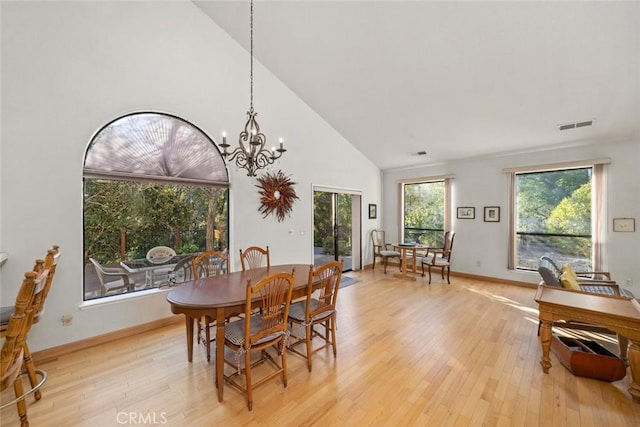 dining area with a notable chandelier, light wood-type flooring, and visible vents