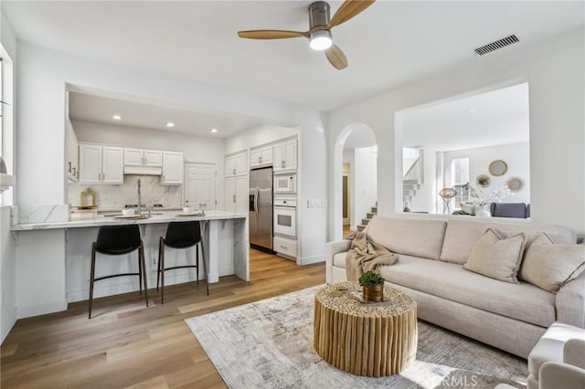 living room featuring ceiling fan and light wood-type flooring