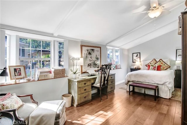 bedroom with lofted ceiling with beams, hardwood / wood-style flooring, and ceiling fan