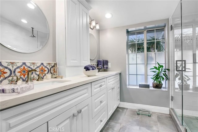 bathroom featuring vanity, a shower with shower door, and a healthy amount of sunlight