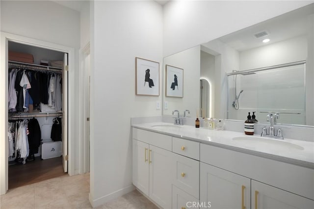 bathroom with walk in shower, tile patterned floors, and vanity