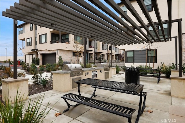 view of patio featuring a grill, a pergola, and exterior kitchen