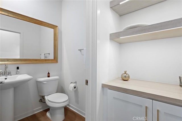 bathroom with sink, hardwood / wood-style floors, and toilet